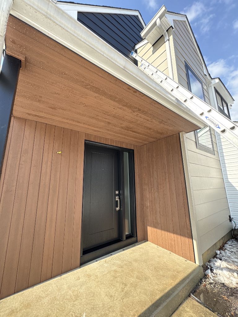 Composite wood-look siding on home entryway with dark door