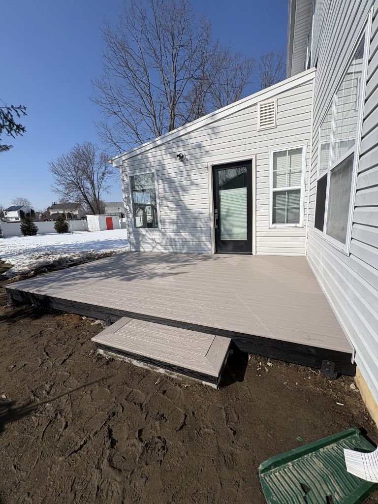 Gray composite ground-level deck with single step — South Jersey