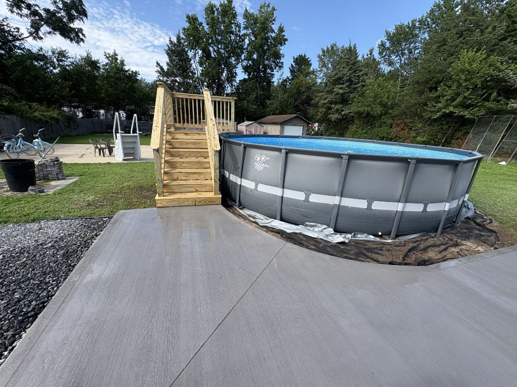 Pressure treated wood deck platform beside above-ground pool