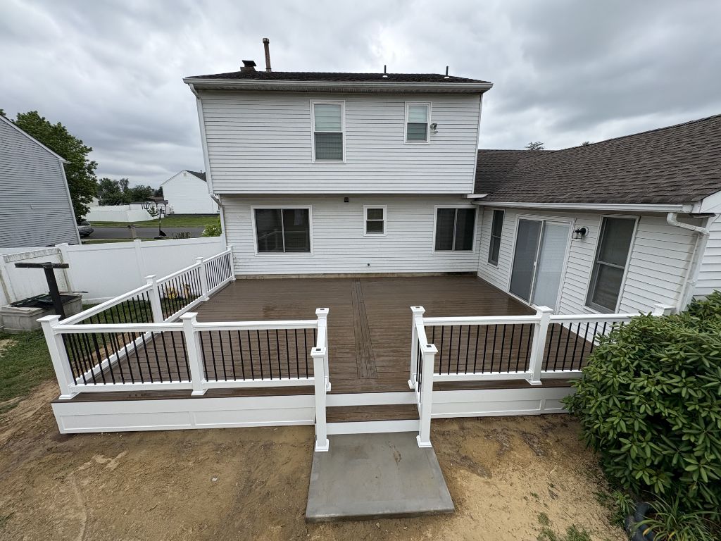 Large brown composite deck with white railing — rear of South Jersey home