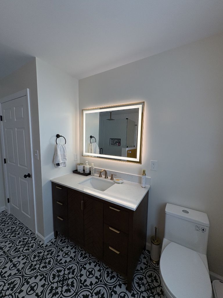 Bathroom remodel with dark espresso vanity, LED mirror and pattern tile floor