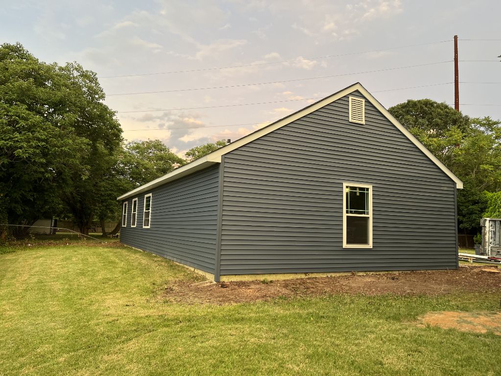 Charcoal blue siding on long ranch-style home