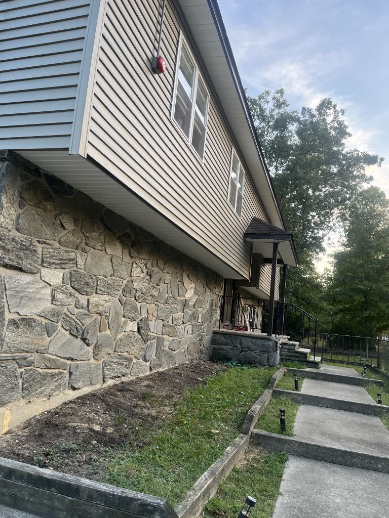 Light siding on home exterior with natural stone lower level