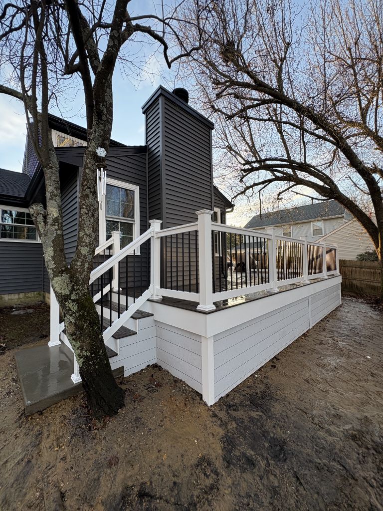 Charcoal composite deck on home with navy siding