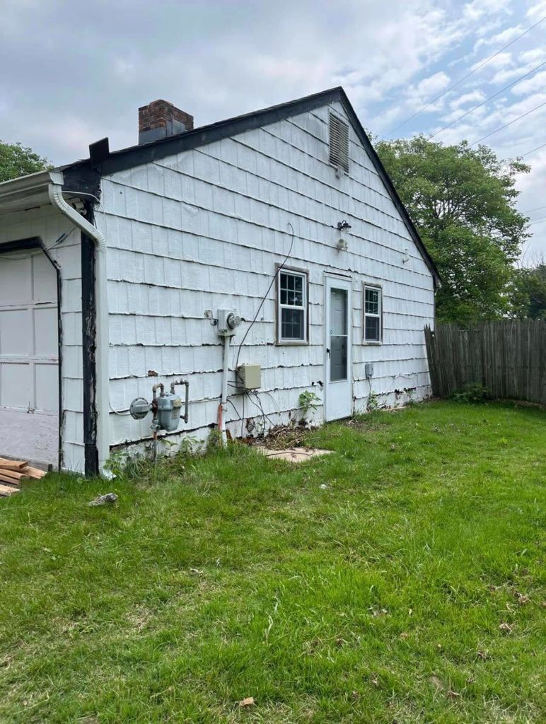 Before: aged white cedar shake siding on side gable end with worn trim and exposed components
